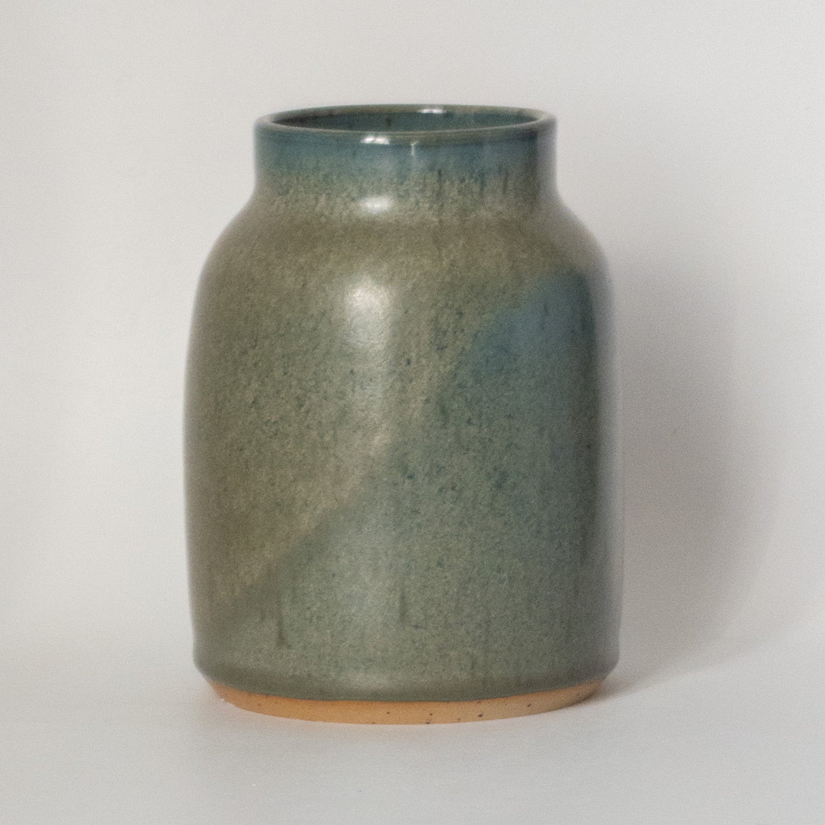 Green ceramic jar on a white background