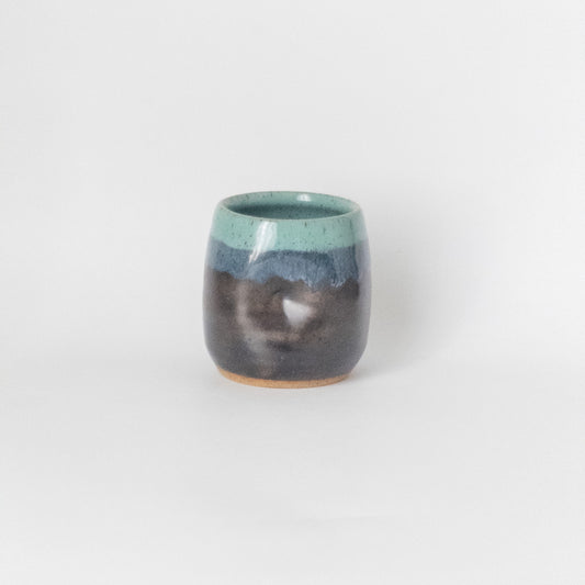 Handmade speckled ceramic mug with thumbprint indentation